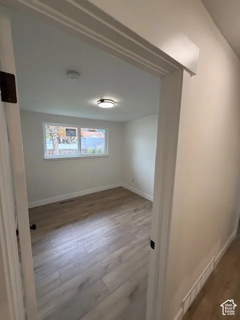 Neutral-toned interior featuring wood-finish flooring, a single-hung window, and a flush-mount ceiling light fixture