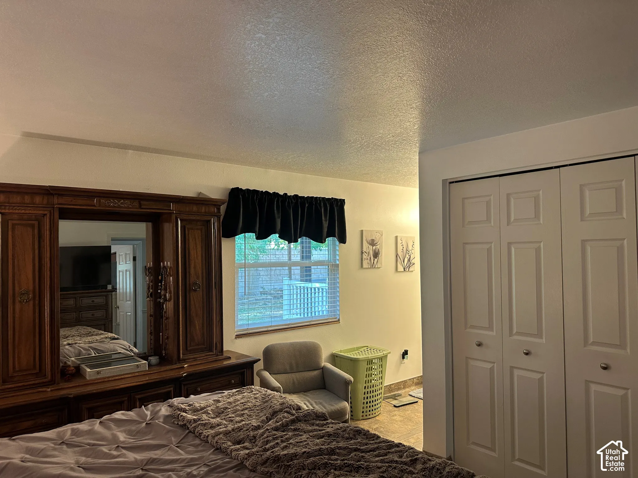 Room featuring a large dual-panel closet with brushed nickel hardware and a window with a neutral valance
