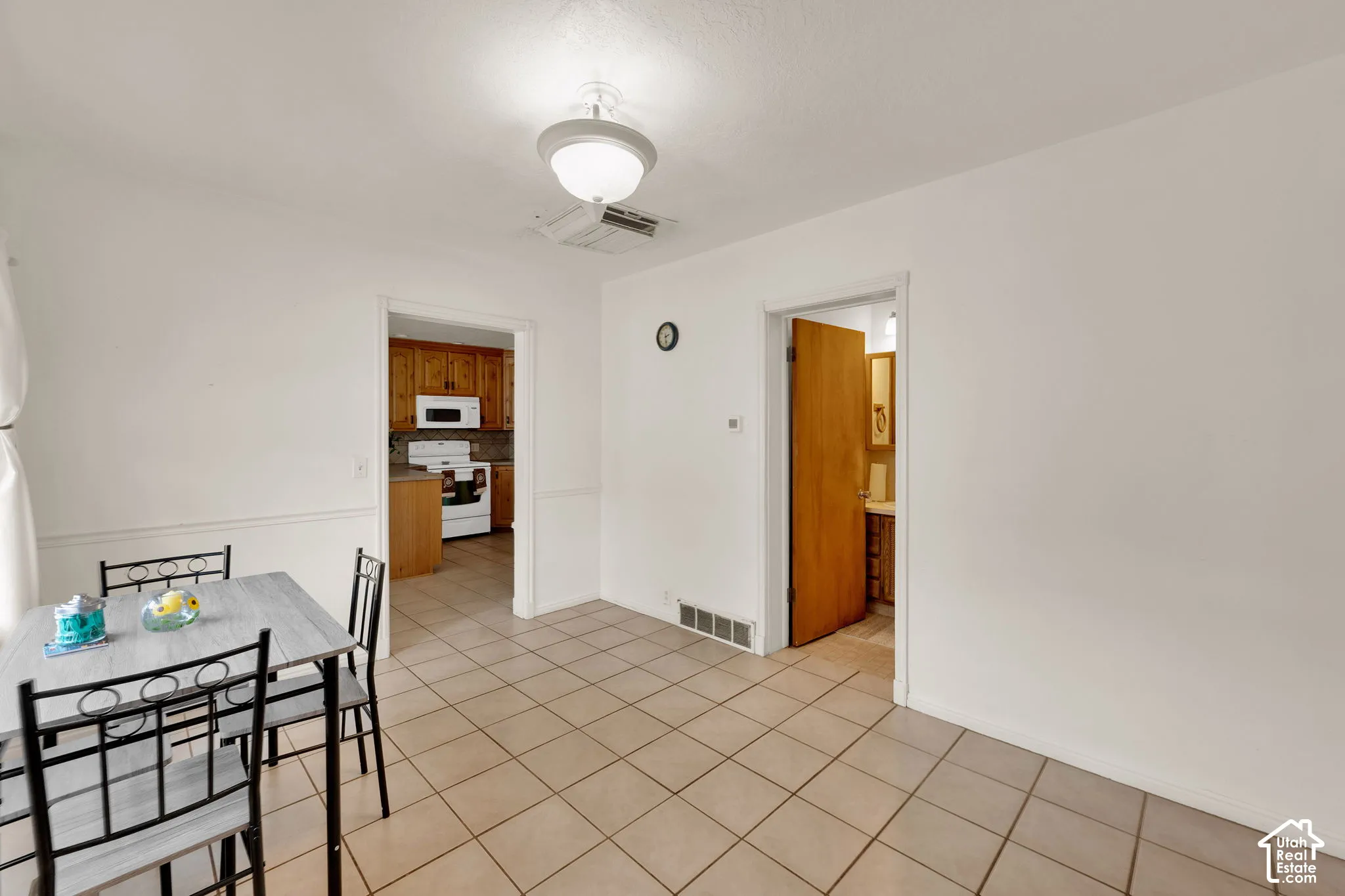 Ceramic tile flooring, semi-flush mount ceiling lighting, and wood-finish interior doors, used as dining area now.