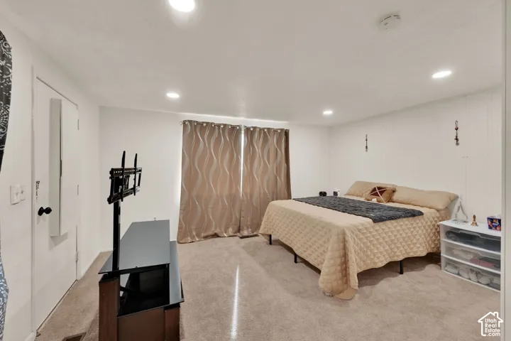 Interior room featuring neutral-toned carpeting, recessed ceiling lighting, and vertical wall paneling