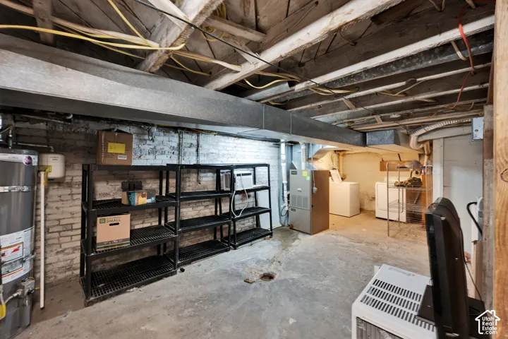 Unfinished lower level featuring exposed ceiling joists, painted brick walls, concrete flooring, and mechanical systems