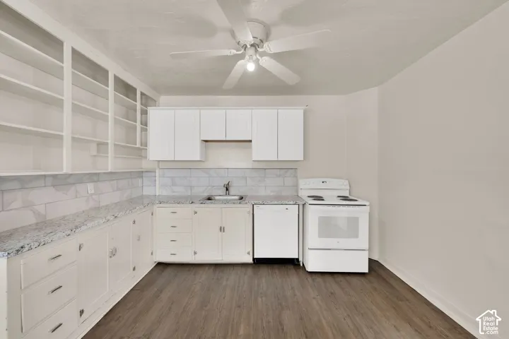 Kitchen featuring stone-finish countertops, built-in open shelving, subway tile backsplash, white cabinetry, and wood-finish flooring