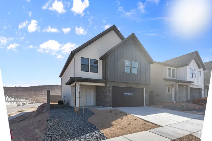 Multi-gabled exterior featuring stucco and vertical siding, stone veneer accents, and a dual-car garage