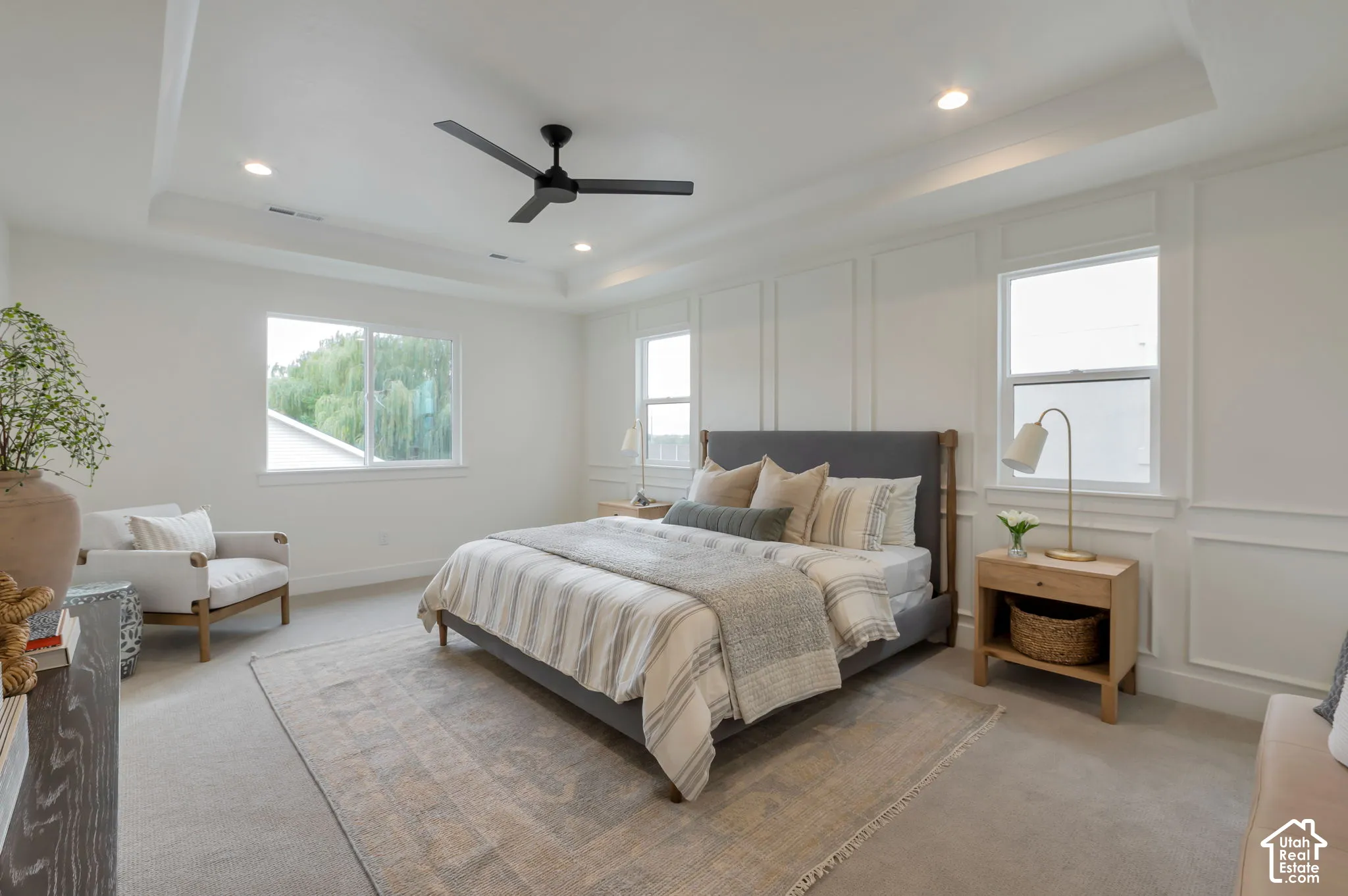 Tray ceiling with recessed lighting, wall molding detail, and a matte black ceiling fan