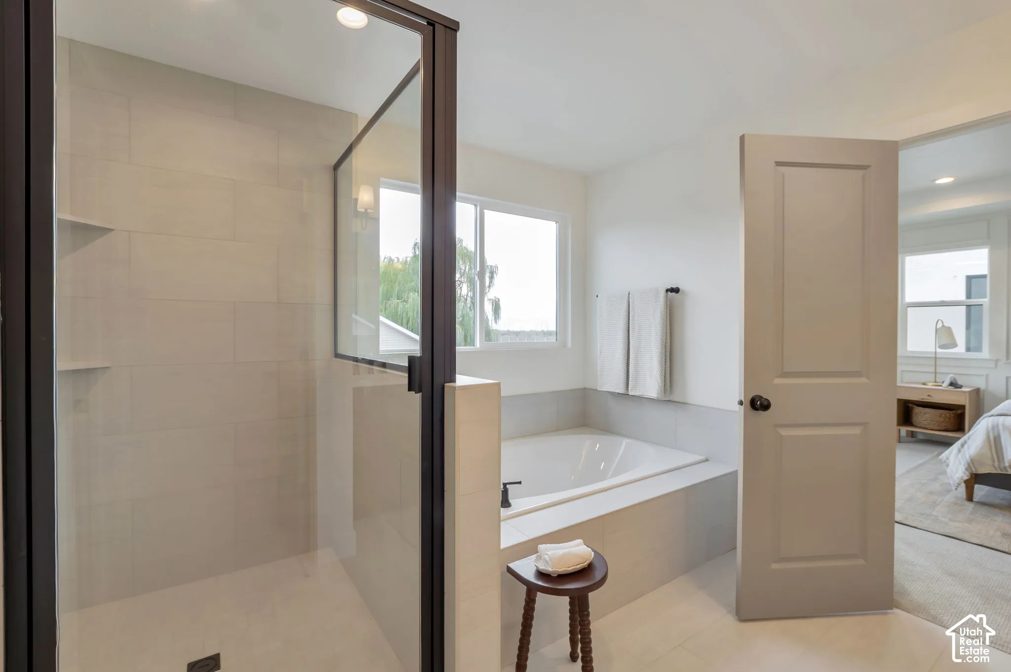 Walk-in shower with floor-to-ceiling tile, glass enclosure, and built-in shelving