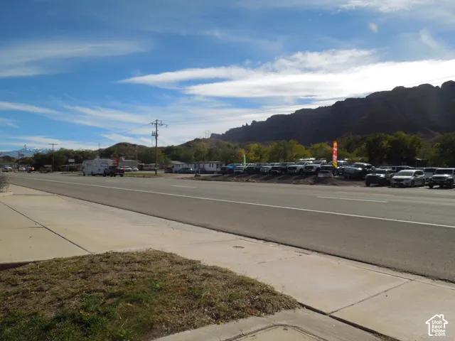 Property exterior featuring concrete sidewalk and prominent mountain backdrop