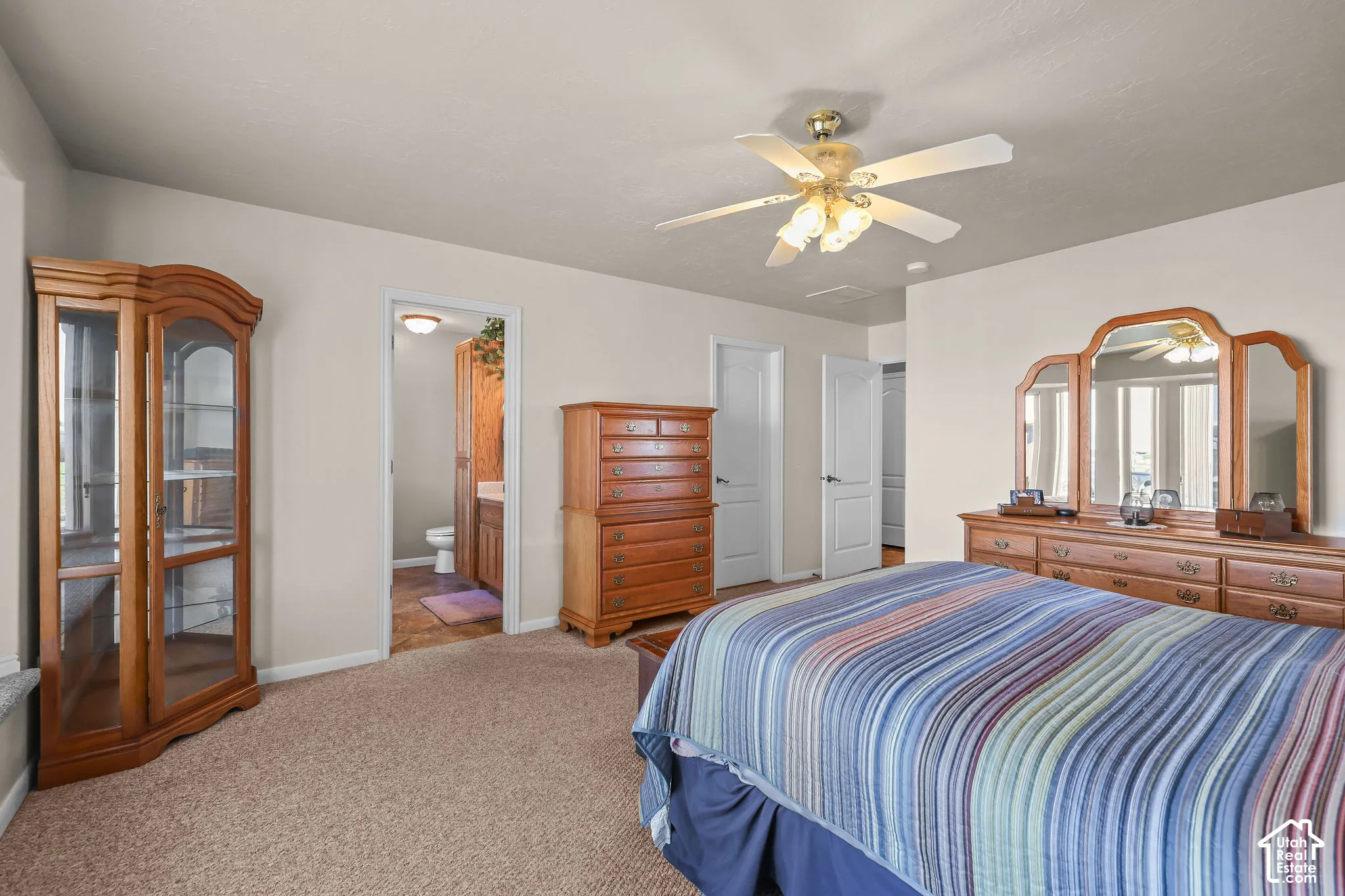 Neutral wall color, wall-to-wall carpeting, and a multi-blade ceiling fan with integrated lighting