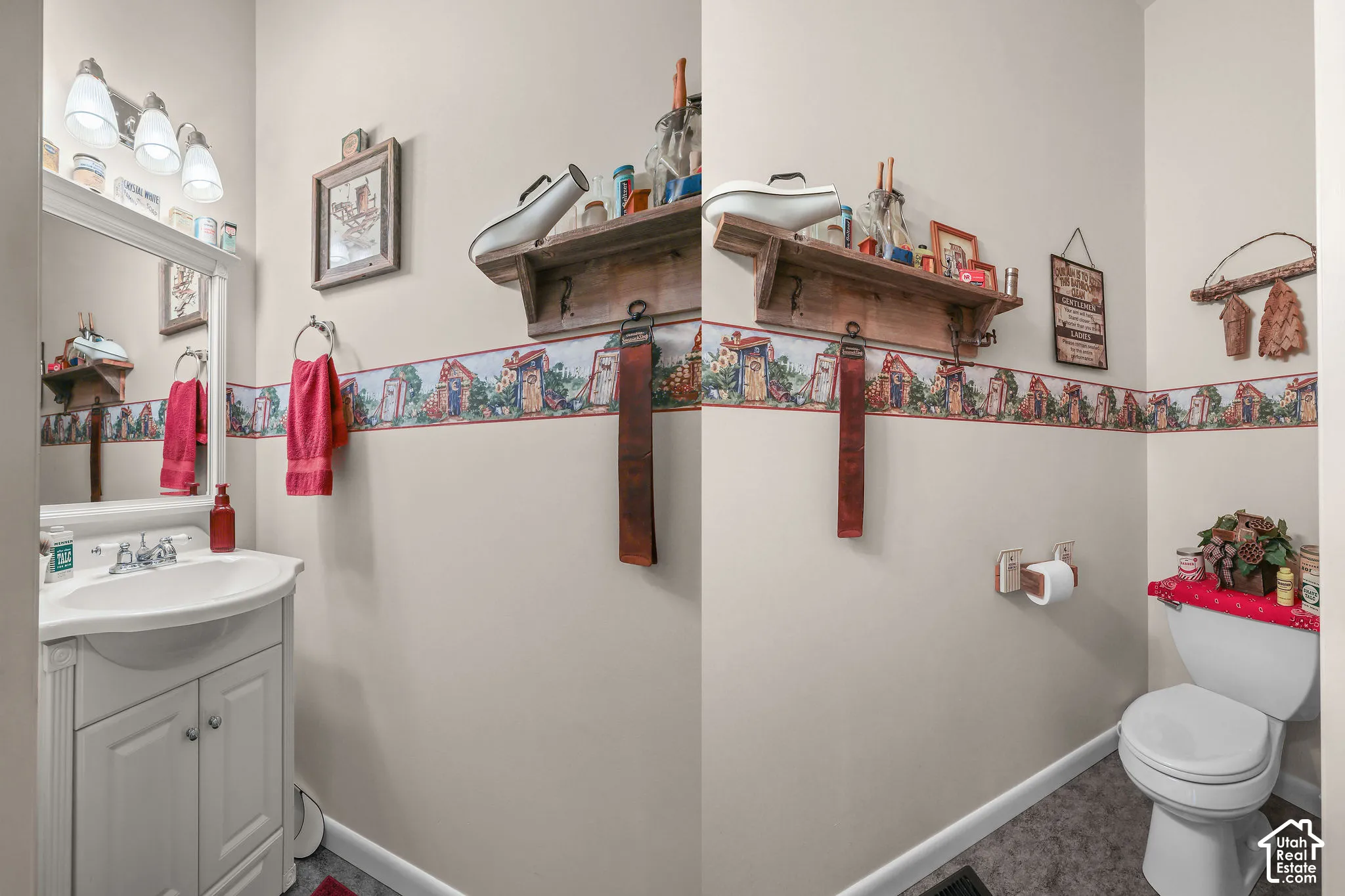 White vanity with integrated sink, three-light fixture, decorative wallpaper border, and wall-mounted shelving