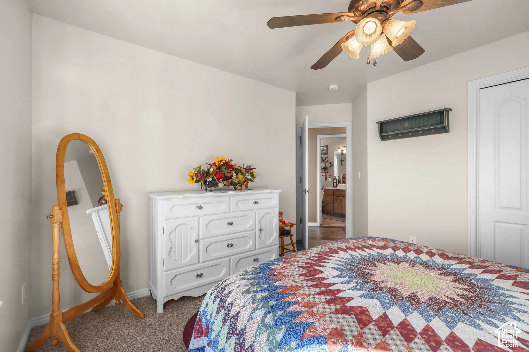 Neutral-toned interior featuring wall-to-wall carpeting, a multi-light ceiling fan, and a paneled closet door