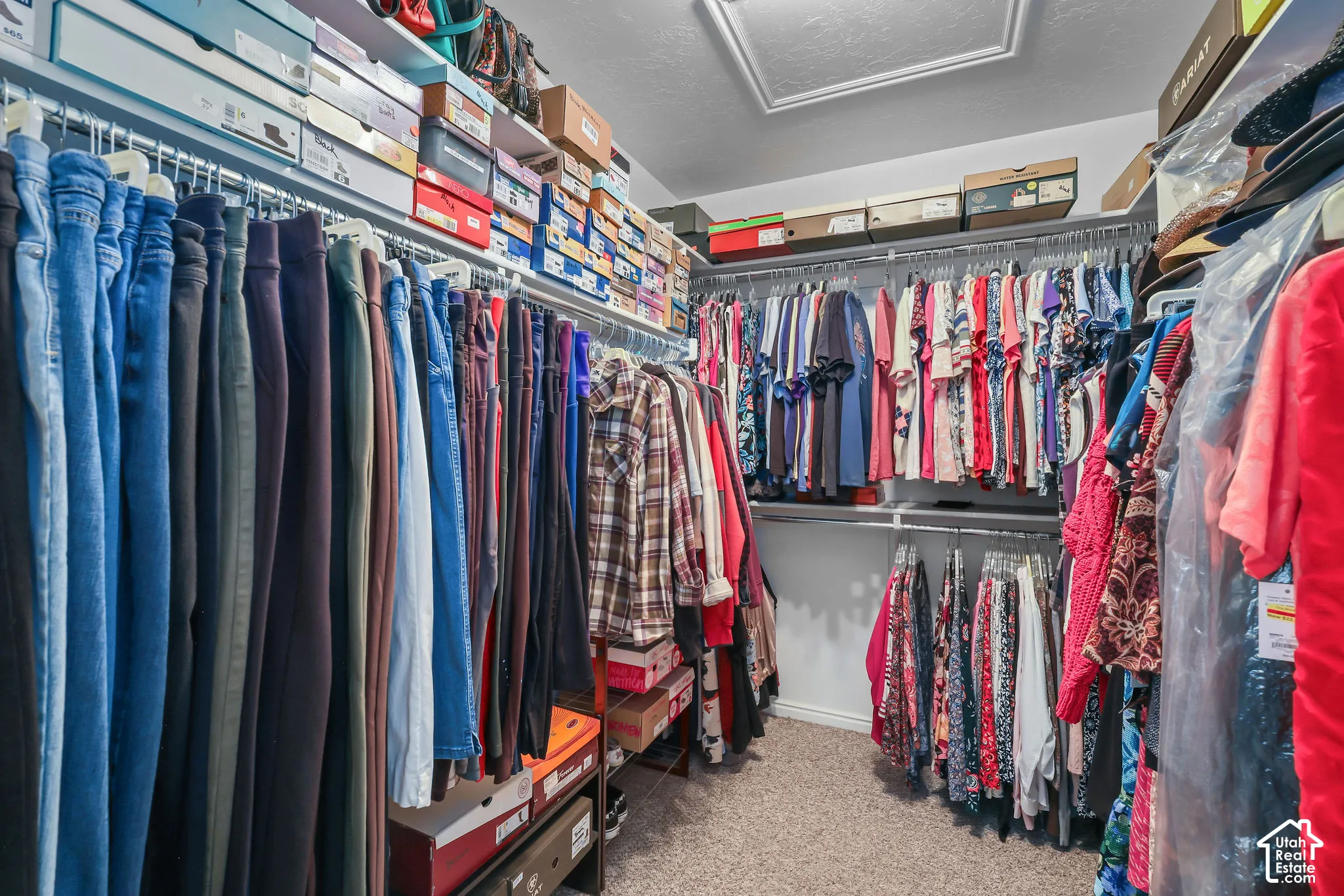 Walk-in closet featuring tiered wire shelving, upper storage racks, and wall-to-wall carpeting
