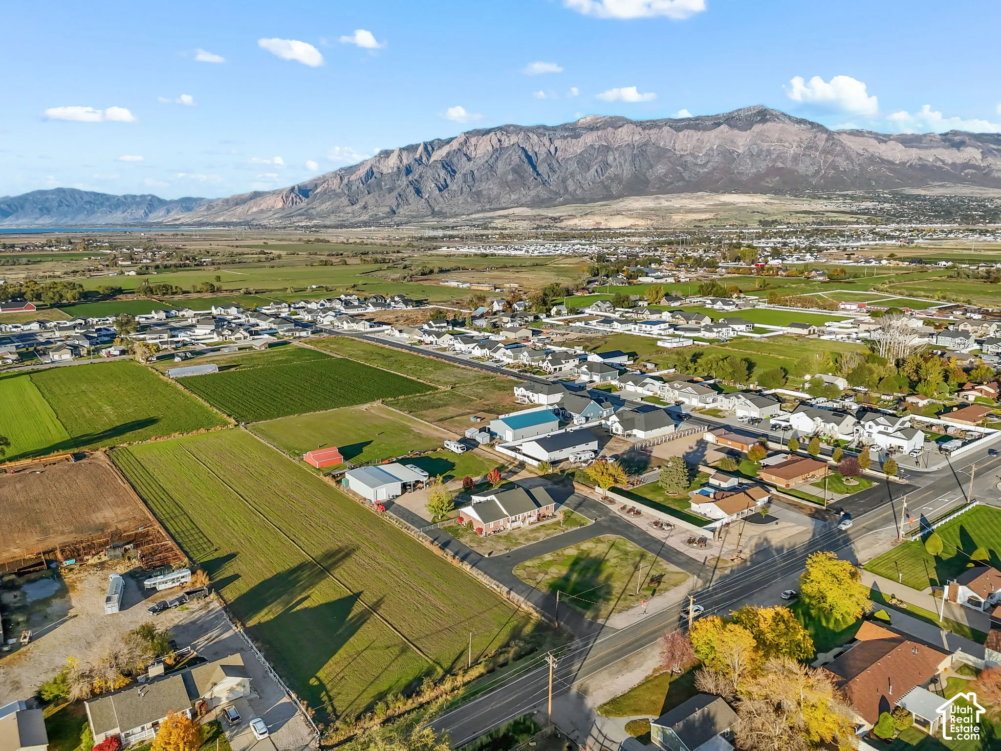 Aerial perspective featuring expansive acreage, rural landscape, and prominent mountain backdrop