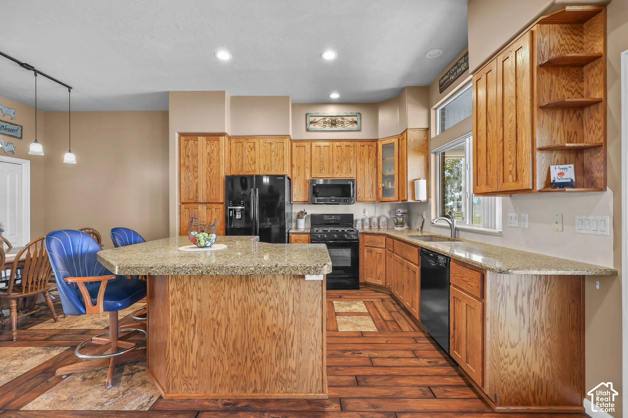 Kitchen featuring natural wood cabinetry, solid surface countertops, recessed lighting, and wood-look flooring