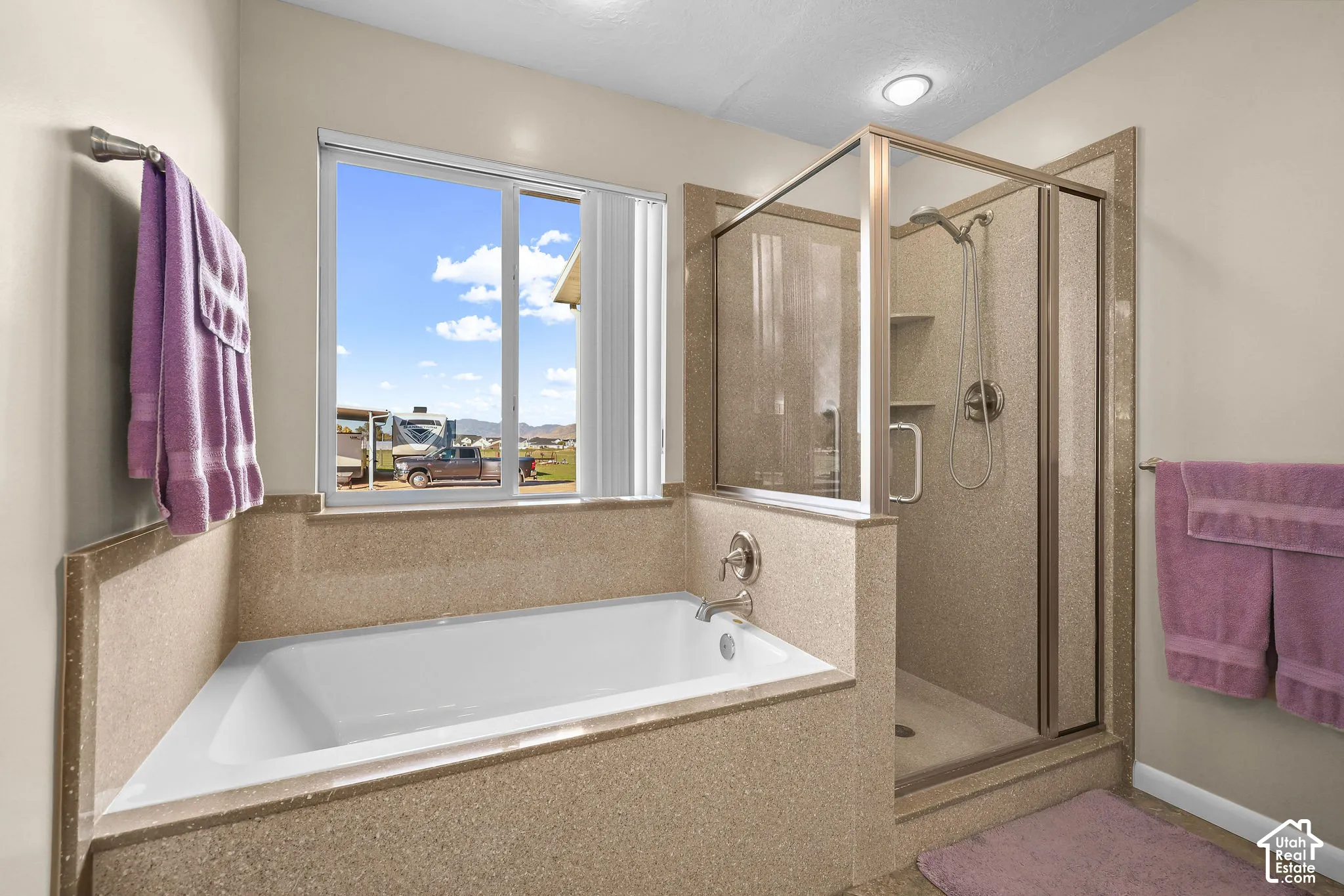 Bathroom featuring a soaking tub, glass-enclosed shower with built-in shelving, and solid-surface surround finishes