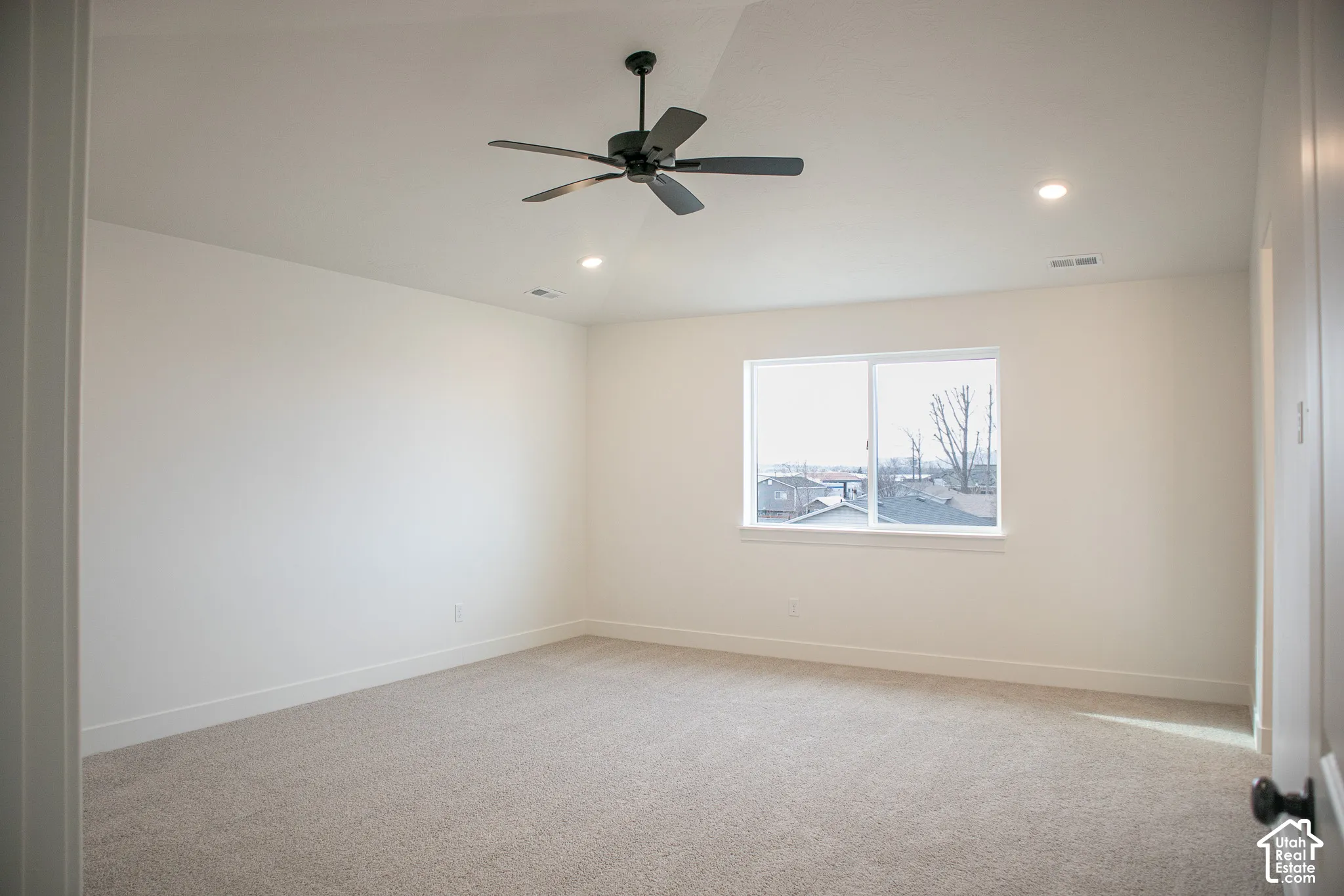 Primary bedroom with vaulted ceiling and recessed lighting