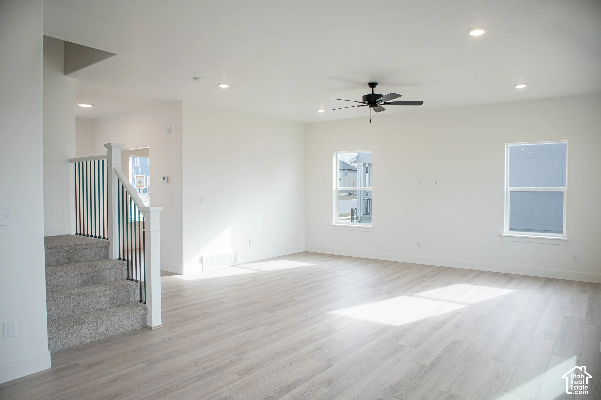 Large family room with ceiling fan and recessed lighting