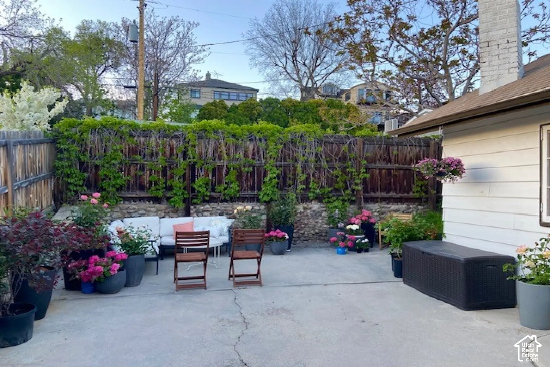 Concrete patio featuring a stacked stone perimeter wall and wood-paneled privacy fencing