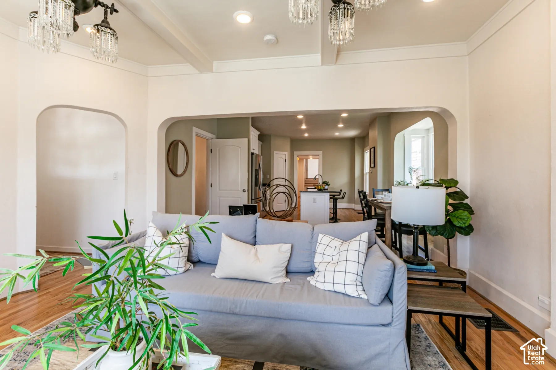Interior space featuring arched entryways, wood-finish flooring, recessed lighting, and ornate crystal-style chandeliers