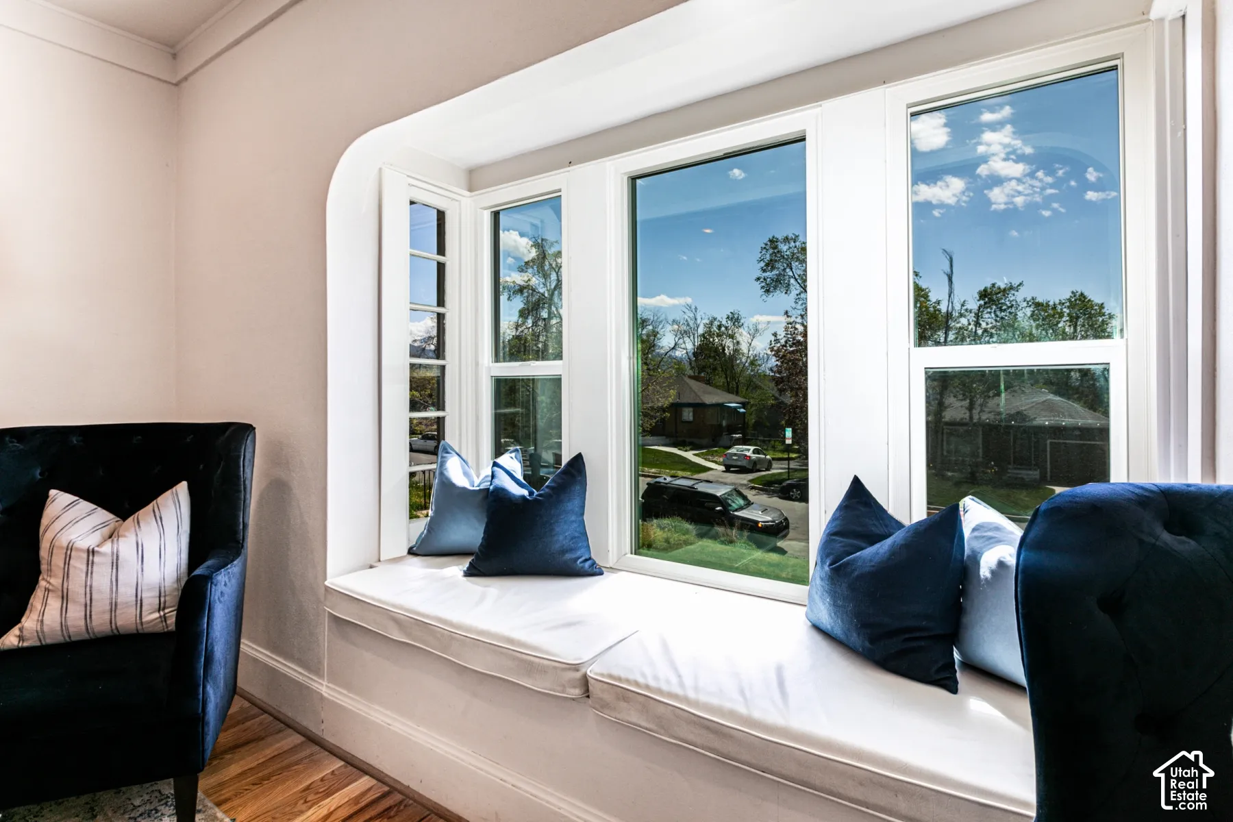 Built-in recessed window seat featuring wood-finish flooring and expansive multi-panel window configuration