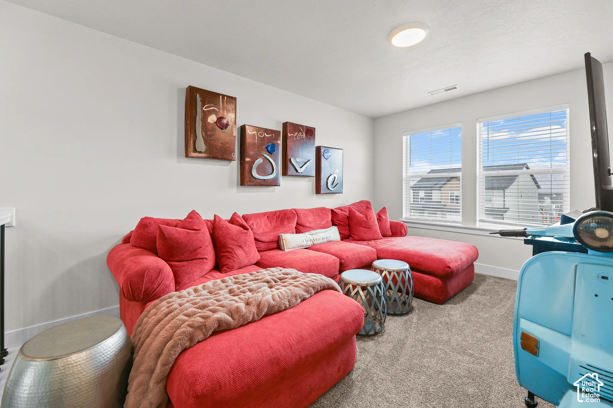 Neutral-toned interior featuring plush carpeting, dual-pane windows, and a flush-mount overhead light fixture