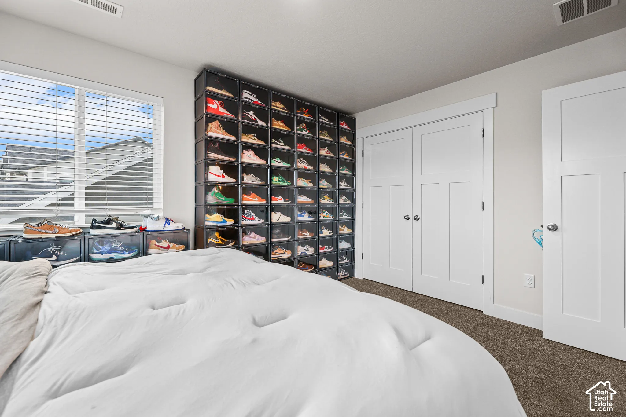 Neutral wall palette, double-door closet with shaker-style detailing, and window with horizontal blinds