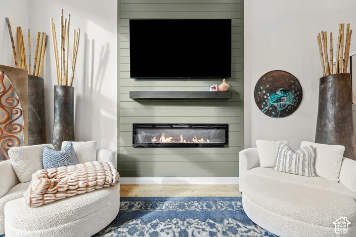 Linear electric fireplace set within a floor-to-ceiling shiplap accent wall, featuring a floating mantel and integrated wall-mounted television