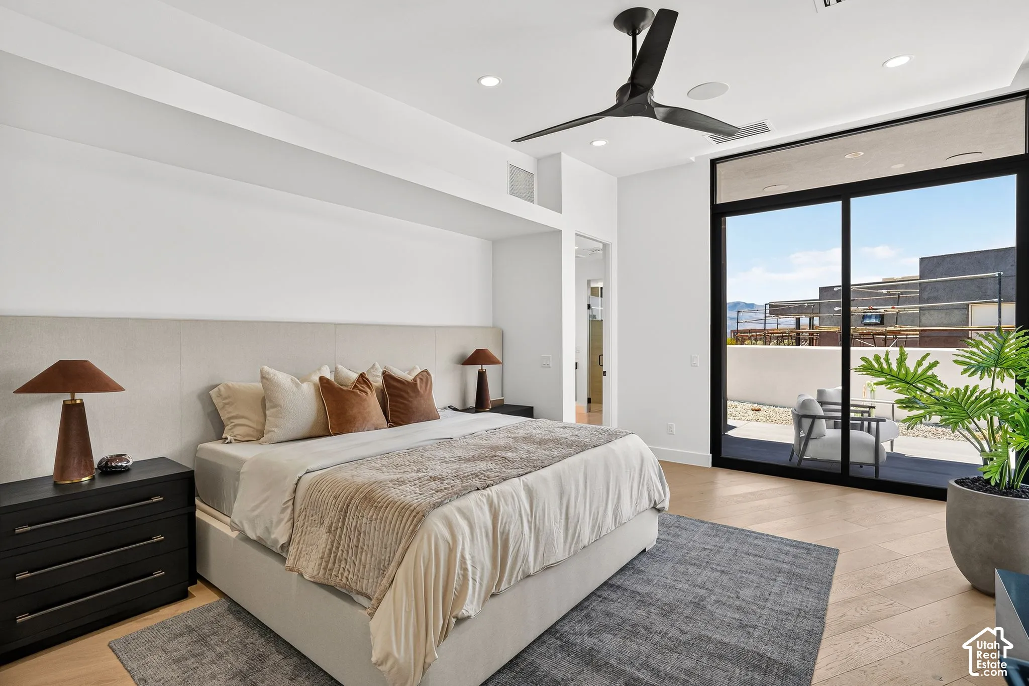 Bedroom featuring wood-finish flooring, a matte black ceiling fan, recessed lighting, and a floor-to-ceiling sliding glass door providing external access