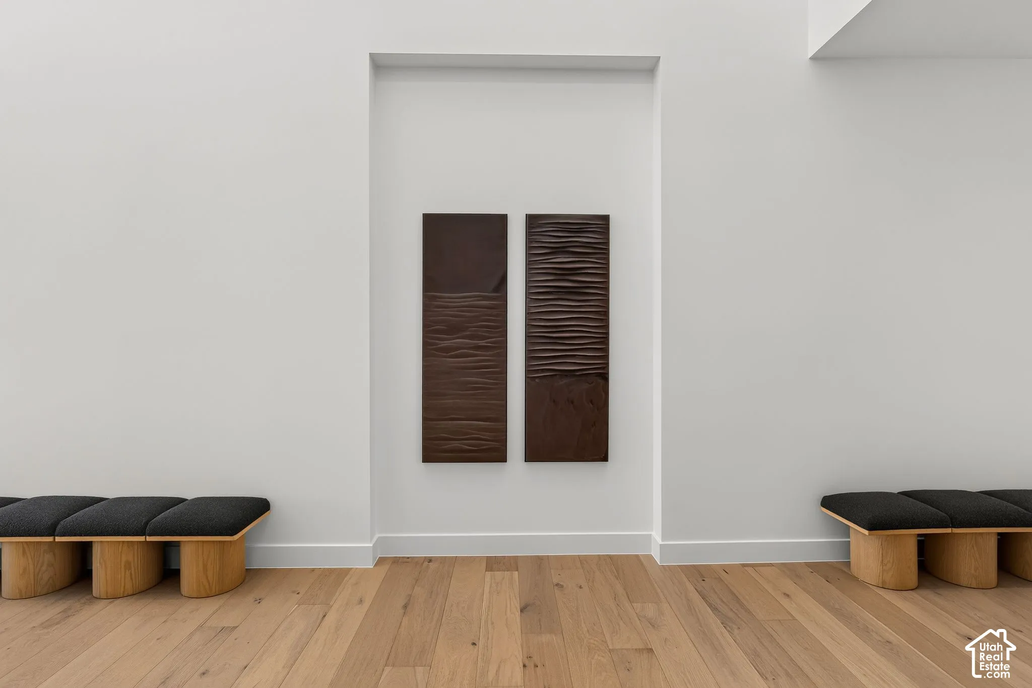 Recessed wall niche featuring textured sculptural wall art and wood-finish flooring