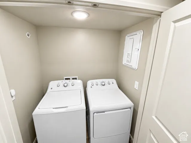 Laundry alcove featuring white top-load washing machine, white clothes dryer, recessed ceiling lighting, and panel door