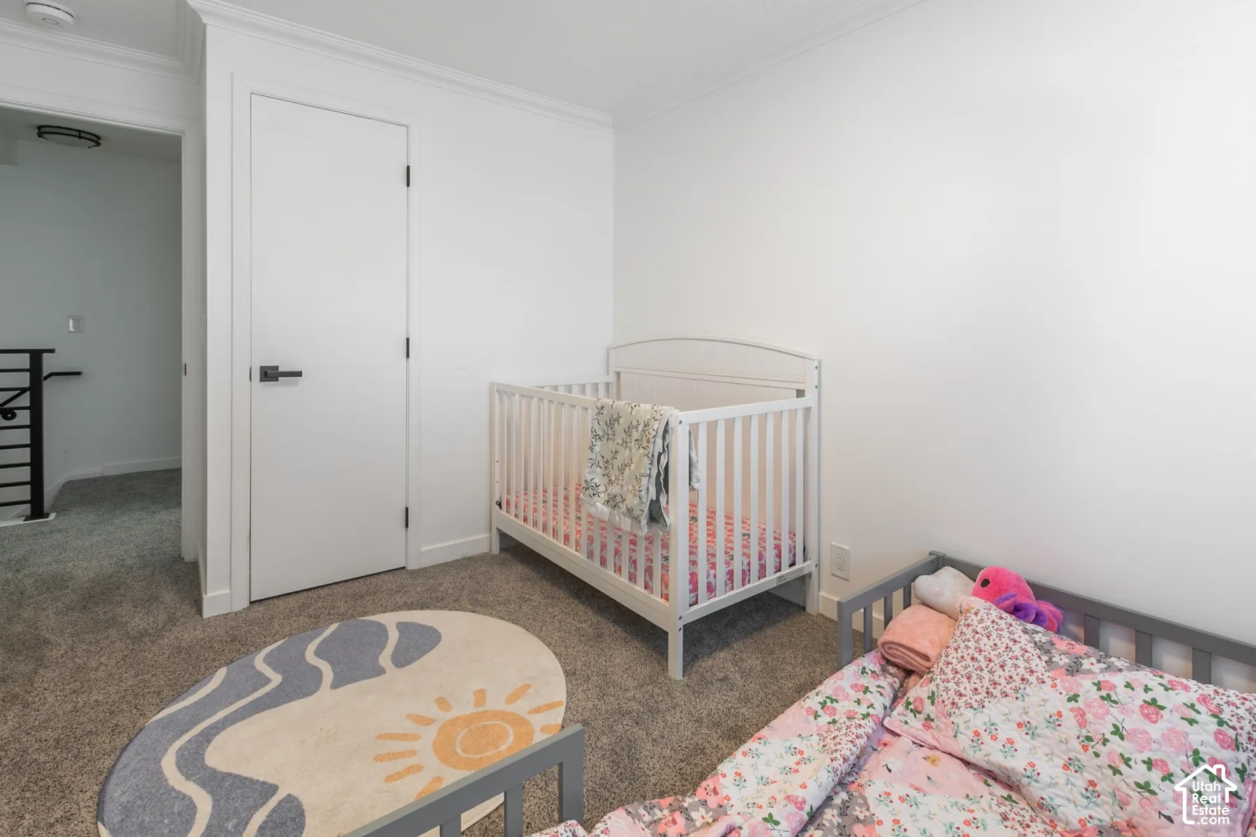 Neutral wall-to-wall carpeting, crisp white wall finish, and a solid-core interior door with matte black hardware