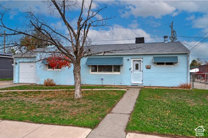 Single-story exterior featuring blue siding, a shingled roof, attached one-car garage, and fixed window awnings