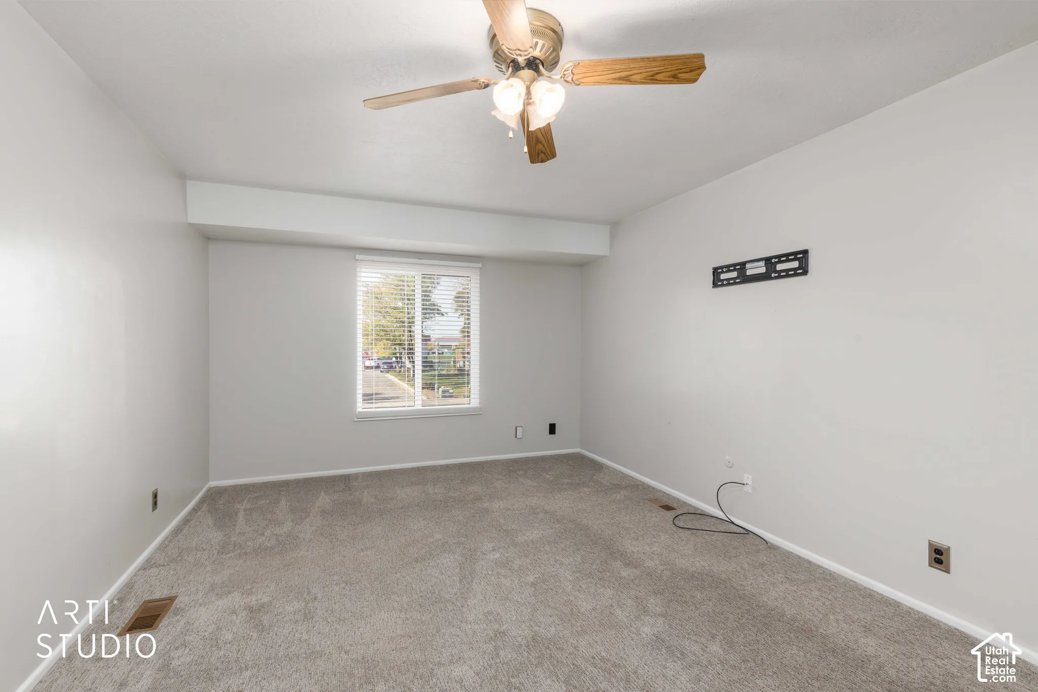Room featuring neutral-toned carpeting, a single-window configuration with horizontal blinds, and a ceiling-mounted fan with integrated lighting
