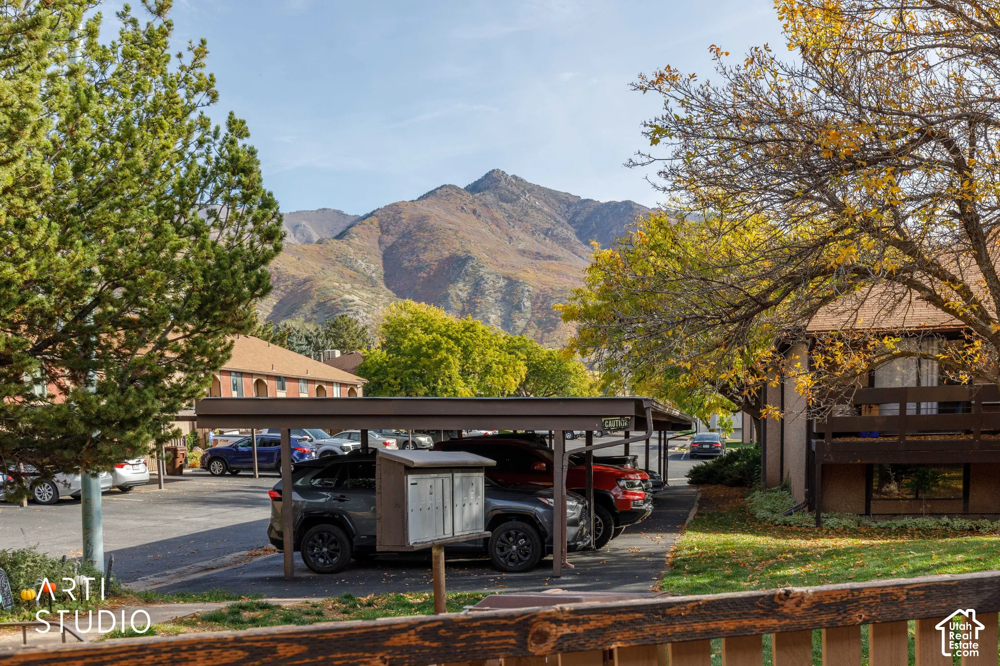 Covered parking structure, mature deciduous trees, and a mountain backdrop