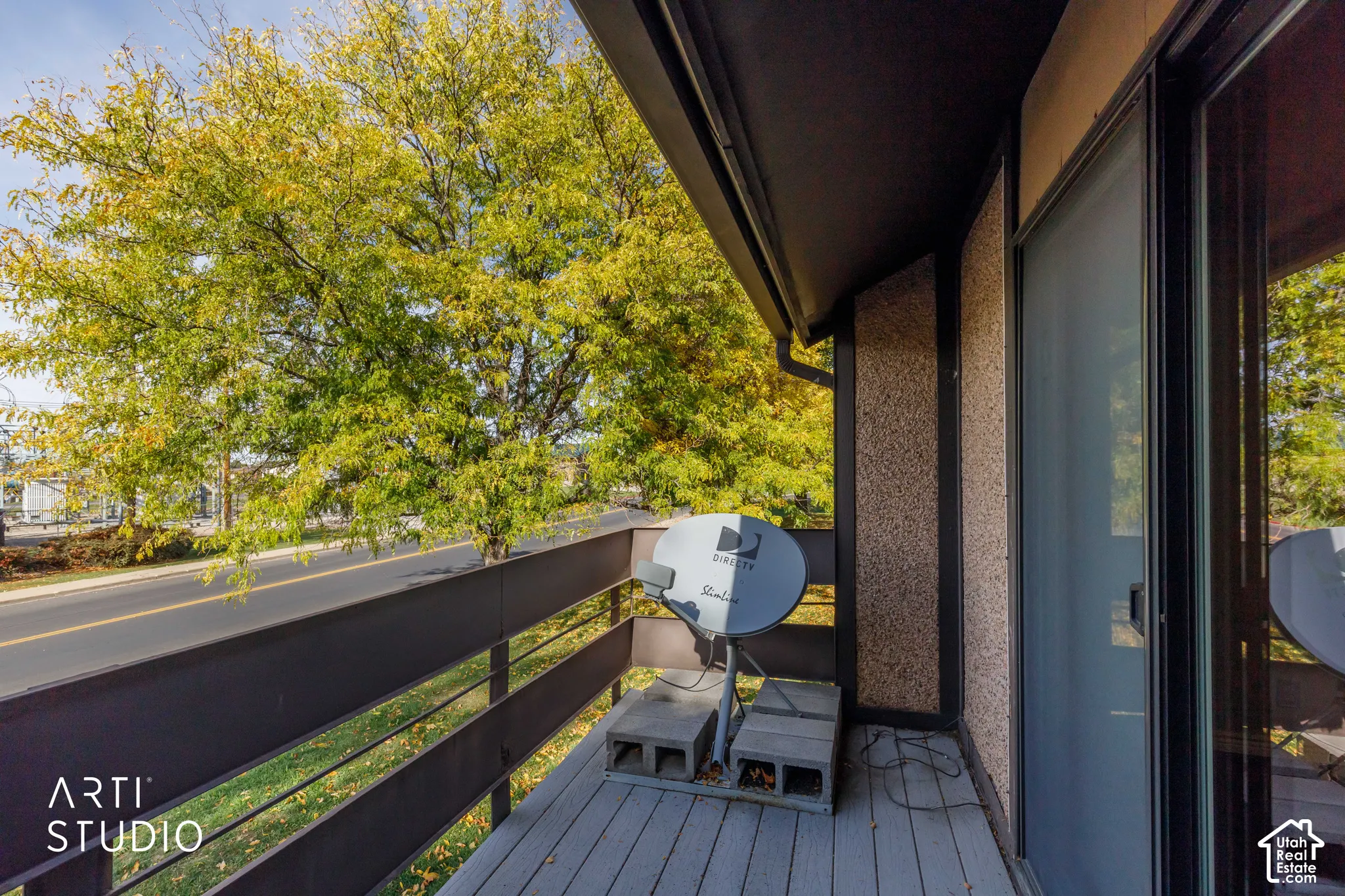 Covered balcony featuring wood-plank flooring and a horizontal rail system