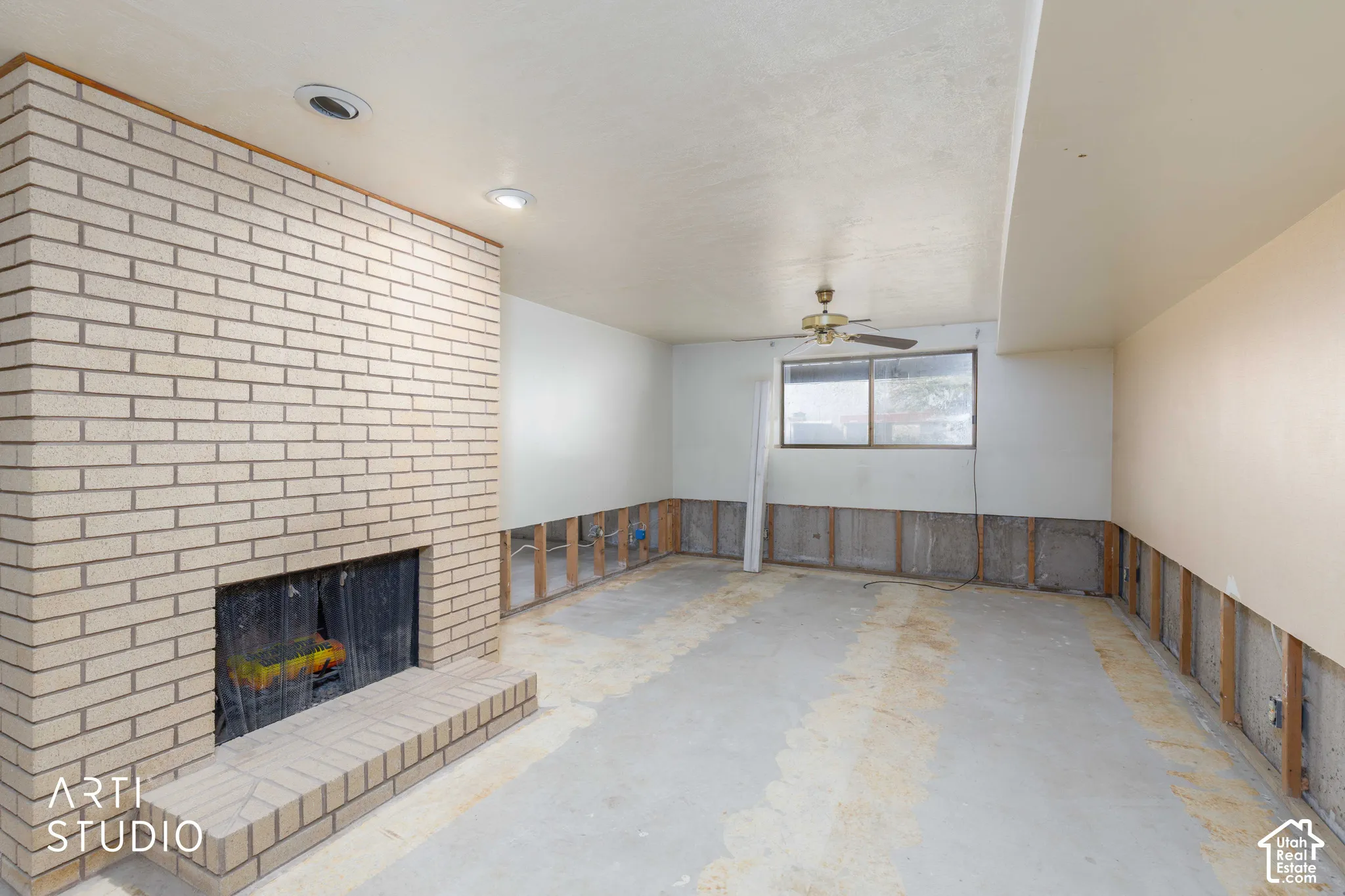 Brick fireplace featuring a raised hearth, recessed lighting, and ceiling fan