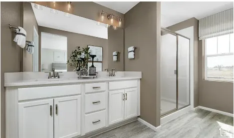 Double vanity with white cabinetry, rectangular under-mount sinks, light-toned countertop, and full-width mirror