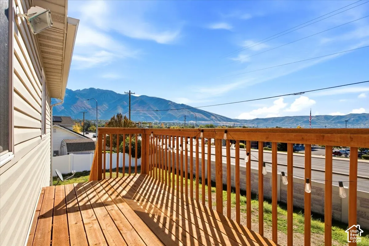 Elevated wood deck featuring vertical wood balusters and a prominent mountain backdrop