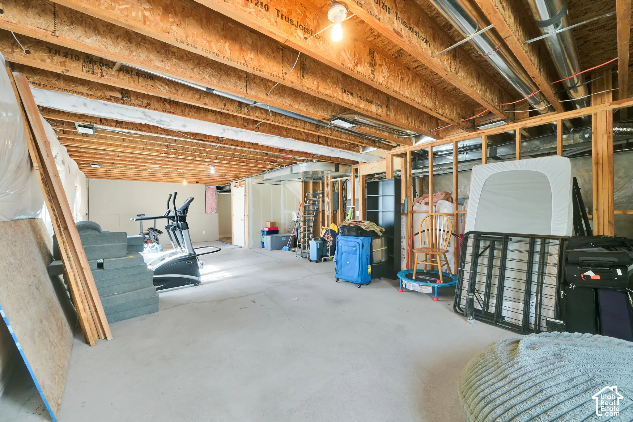 Unfinished lower level featuring exposed wood joist ceilings, concrete flooring, and open wood stud wall framing