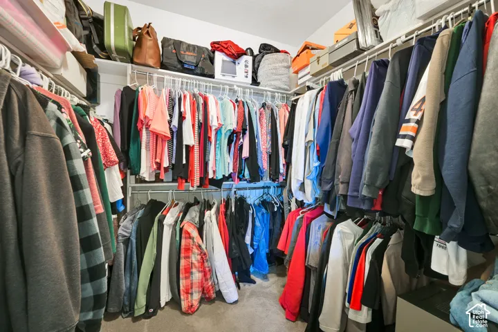 Walk-in storage space featuring dual-level white wire shelving units and carpeting