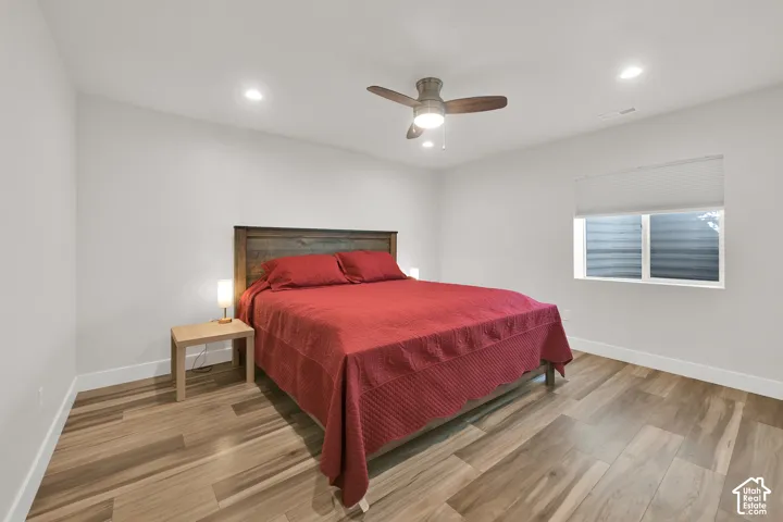 Room interior featuring wood-finish flooring, recessed lighting, and a ceiling fan