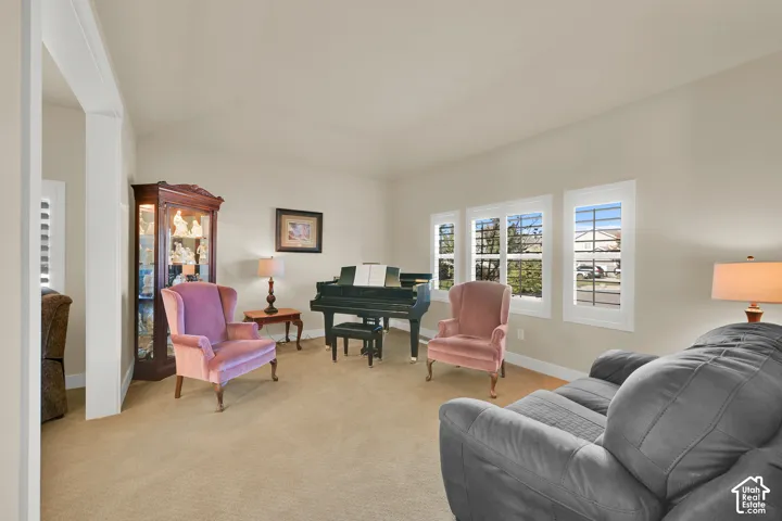 Vaulted ceilings, neutral wall color, and triple windows with white casings