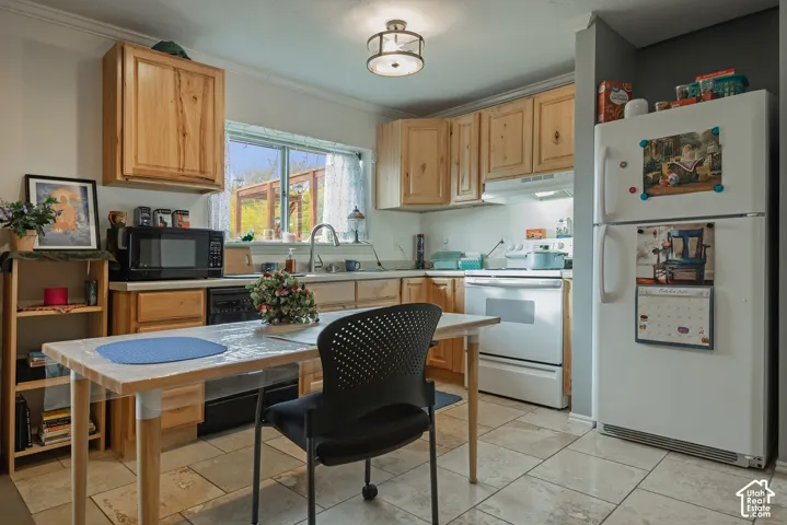 Kitchen featuring natural finish cabinetry, light-toned stone tile flooring, a stainless steel sink with a goose-neck faucet, and a flush-mount light fixture