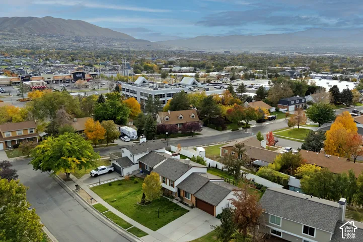 Aerial view of a residential property featuring an attached two-car garage, concrete driveway, and expansive mountain backdrop