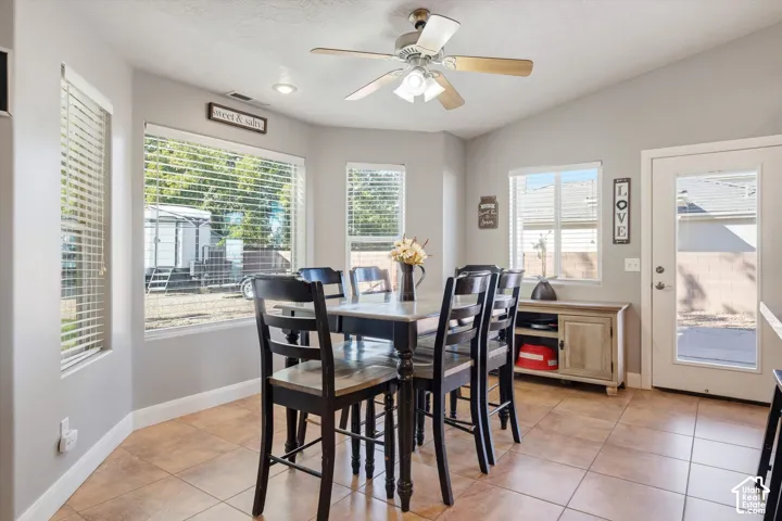 Bay window with large pane windows, ceramic tile flooring, recessed lighting, ceiling fan with light kit, and exterior access door