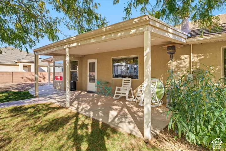 Covered concrete patio with recessed lighting, stucco exterior, and attached metal support columns