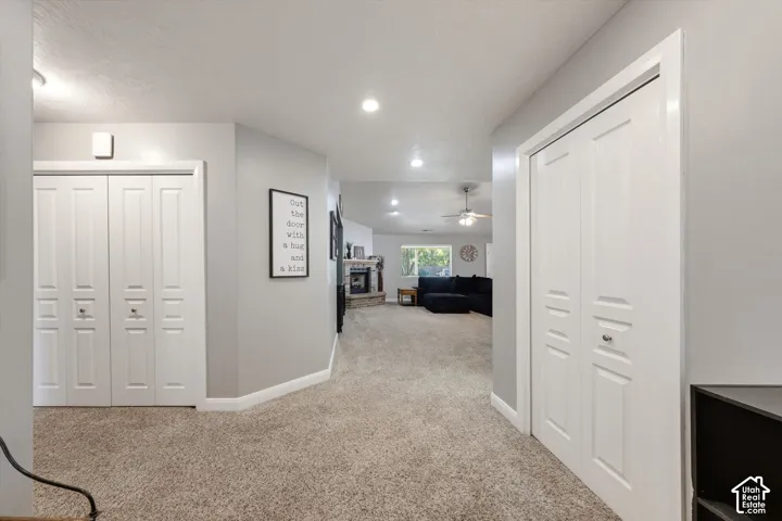 Neutral wall paint, recessed lighting, dual white bifold closets, and a masonry fireplace