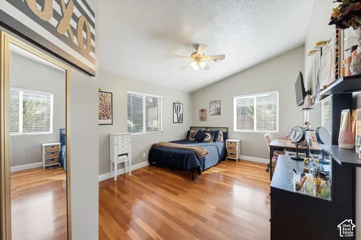 Vaulted ceilings, wood-finish flooring, multi-pane windows, and a ceiling-mounted light fixture