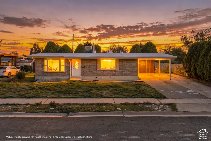 Single-story brick exterior featuring a bay window, covered carport, and concrete driveway