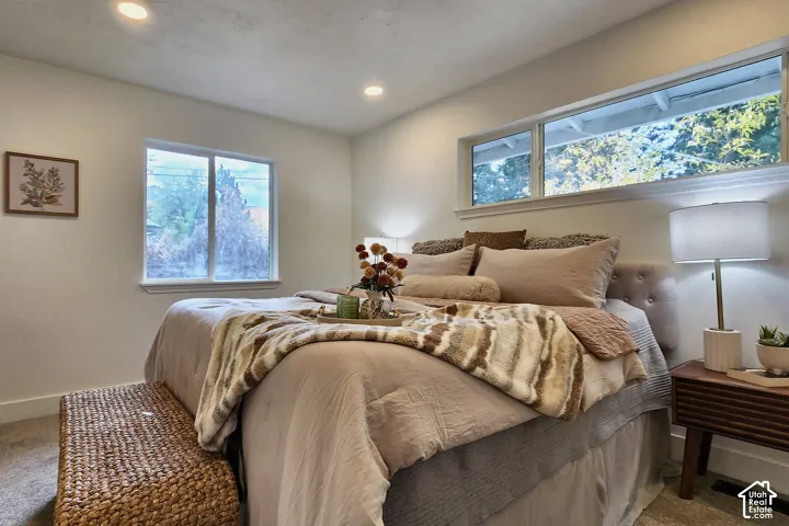 Neutral-toned room featuring recessed lighting, carpeted flooring, a horizontal rectangular window, and an additional square window