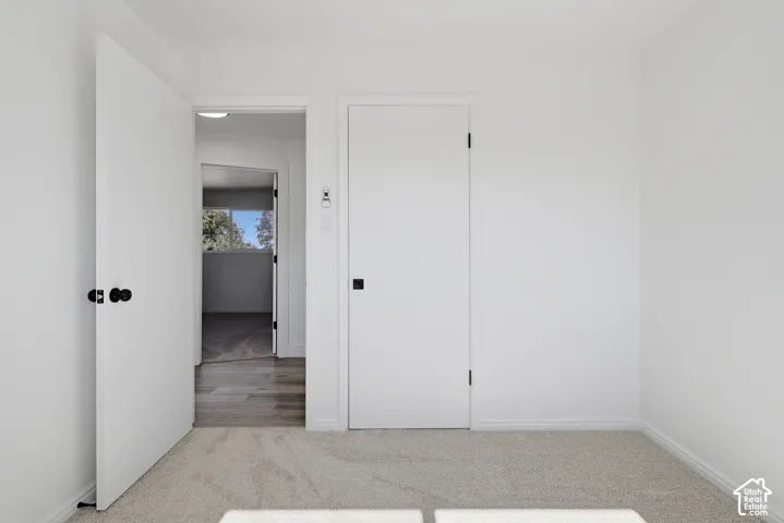 Neutral-toned carpeted flooring, minimalist flat-panel doors, and matte black hardware