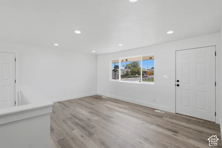 Neutral interior featuring wood-finish flooring, recessed lighting, and a multi-pane window